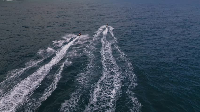 Aerial view of a personal watercraft speeding through the waves, creating a mesmerizing trail. Royalty-Free Stock Footage #1109098181