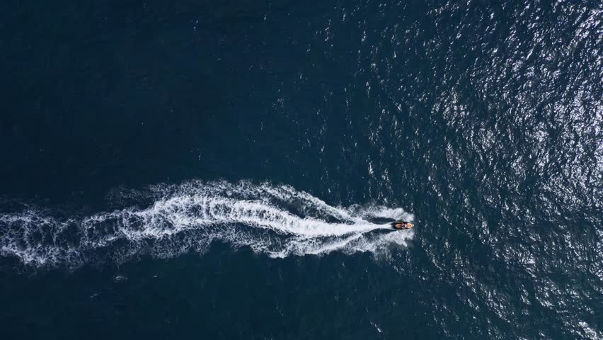 Aerial view of a personal watercraft speeding through the waves, creating a mesmerizing trail. Royalty-Free Stock Footage #1109098185