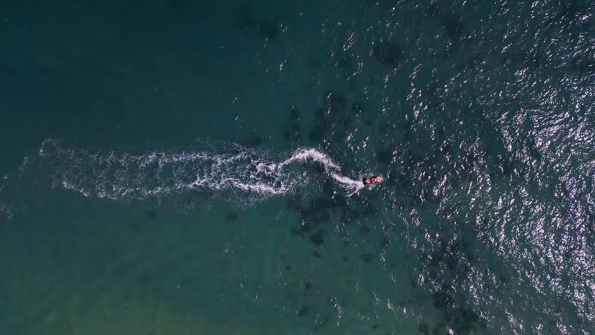 Aerial view of a personal watercraft speeding through the waves, creating a mesmerizing trail. Royalty-Free Stock Footage #1109098203