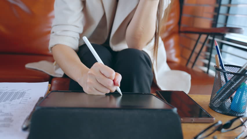 Asia freelance Asian businesswoman or female boss using a digital tablet touchpad to take notes and plan her work in internet. | Shutterstock HD Video #1109099109