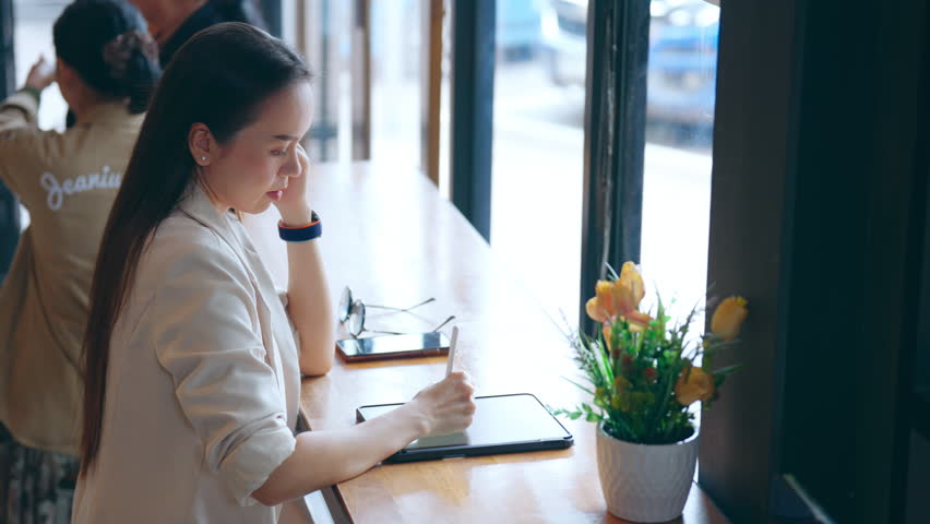 Asia freelance Asian businesswoman or female boss using a digital tablet touchpad to take notes and plan her work in internet. | Shutterstock HD Video #1109099113