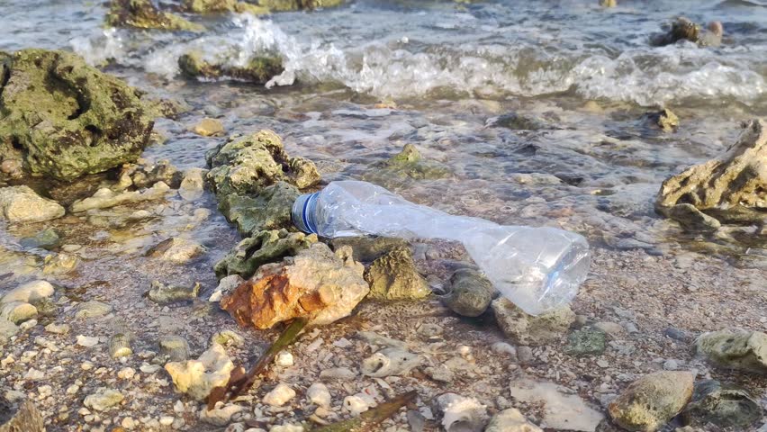 Video footage of crashing sea waves carrying plastic drink bottle waste. the ecological concept of going green to reduce the use of plastic bottles which are difficult to recycle | Shutterstock HD Video #1109099775