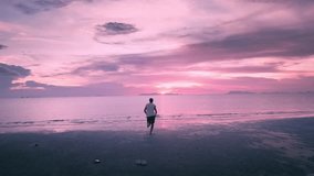 Sunset Escape, Man jogging to Sea, Concept of Unrestricted Living. Chasing dreams, Happy man running to sun, enjoy life, feel free on summer beach at sunset. man raises hands and rejoices in freedom - Powered by Shutterstock - Get 15% off with code: PIKWIZARD15