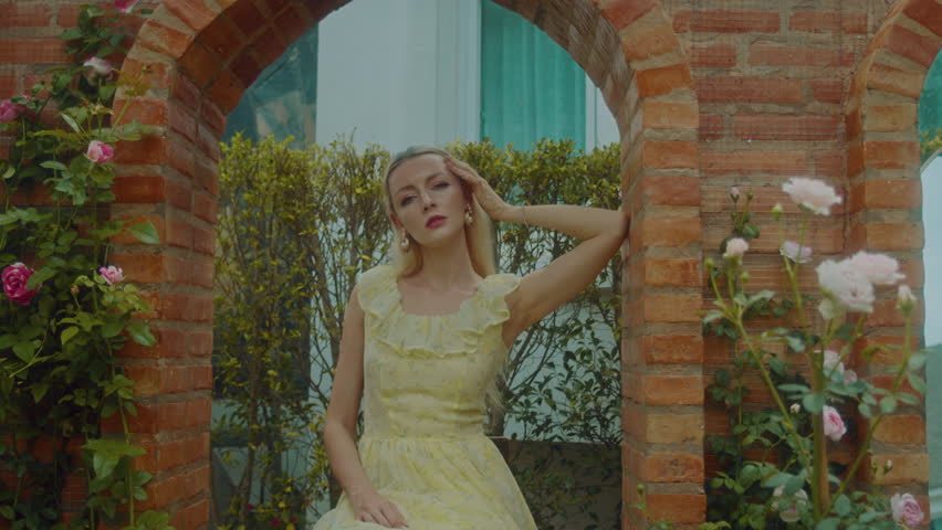Portrait of a young girl in a vintage dress in the courtyard of a mansion