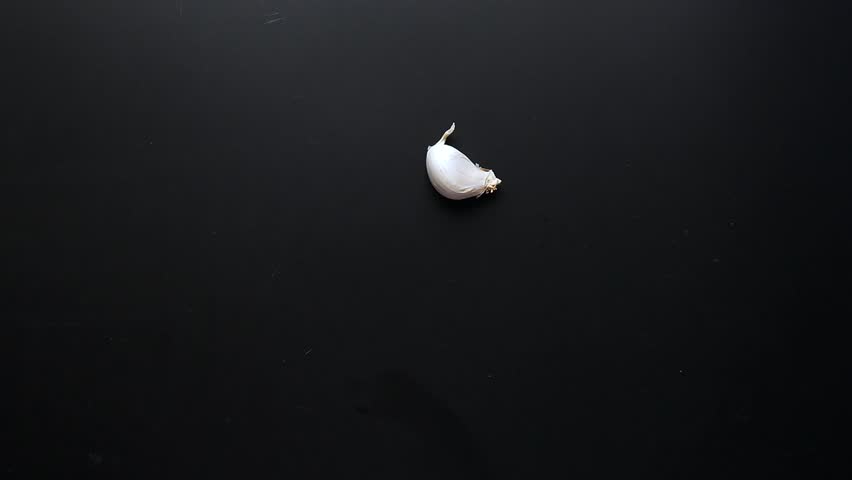  slow motion of garlic fallen on black background 