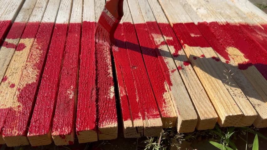 Hand with brush paints thin wooden markers with red paint, indicating danger of mining. Demining in Ukraine during war | Shutterstock HD Video #1109105885