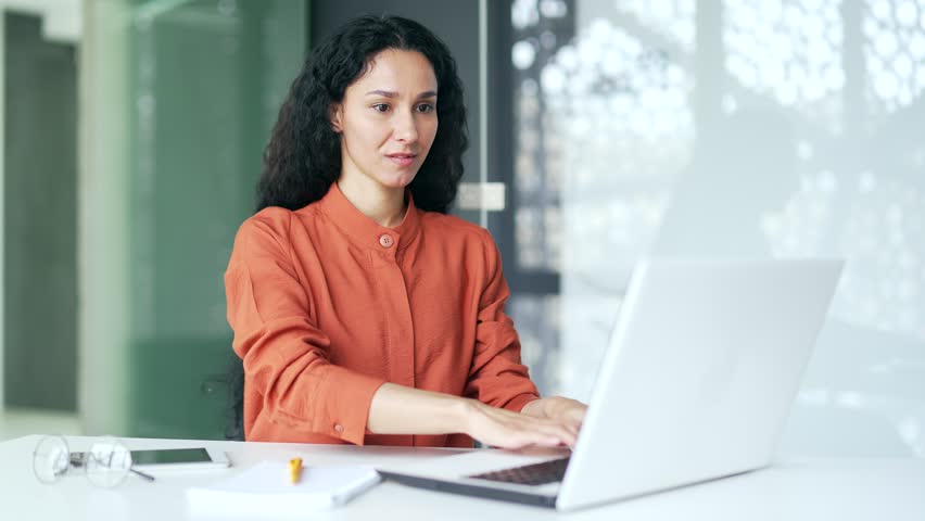 Happy young female employee finished work on laptop sitting at workplace inoffice. Smiling satisfied businesswoman puts her hands behind her head, rests with closed eyes, breathes deeply. Work done Royalty-Free Stock Footage #1109109345