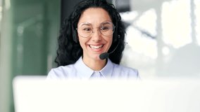 Close up. Confident woman in wireless headset customer service operator talking on video call using laptop sitting in modern office. Agent of the call center advises the client, answering questions - Powered by Shutterstock - Get 15% off with code: PIKWIZARD15