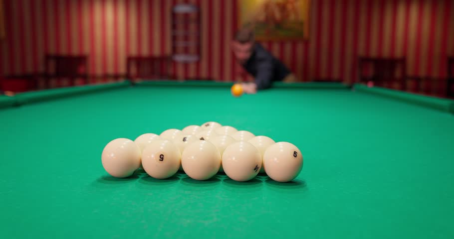 A young man plays American billiards. Russian billiards, an American in a billiards club and bar. Dark colors in the billiard club. A man pockets snooker balls. | Shutterstock HD Video #1109109867