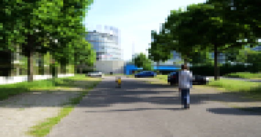 In a pixelated metaverse representation, a mother and her son walk along a street, framed by a sprawling parking area with a parliament building in the backdrop.-- Royalty-Free Stock Footage #1109116915