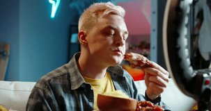 Male blogger eating chicken for video. Mukbank video for social networks, cook, experienced chef eats chicken legs, tastes restaurant food, criticizes, enjoys food online for videos on internet.