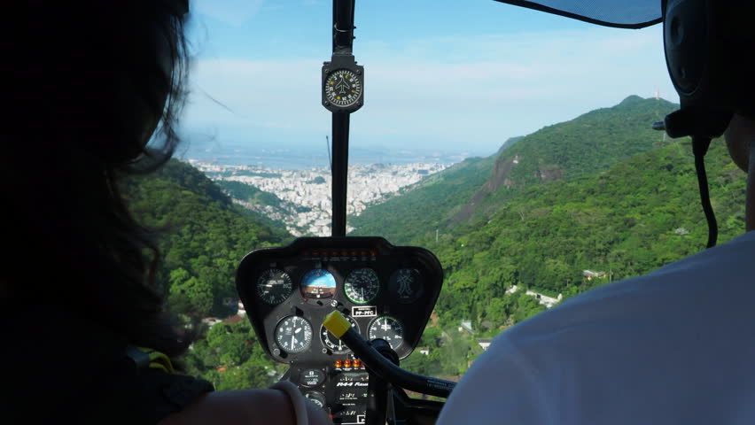 A helicopter flying over the lush mountains of Rio de Janeiro, Brazil, approaching the vibrant Rio cityscape during summer, daytime.