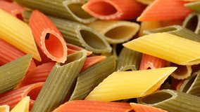 Zoom frame raw three coloured Italian pasta penne close up, rotation
