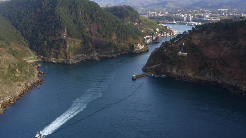 beautiful aerial view of a boat leaving Pasaia Bay.