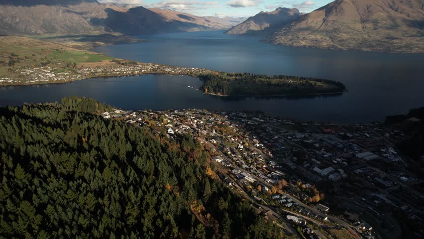 Famous resort town and peninsula on big lake, mountain vista on background. Queenstown, New Zealand Royalty-Free Stock Footage #1109117657