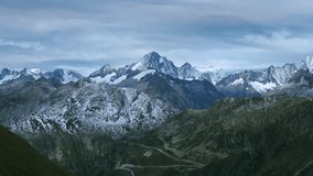 Breathtaking panoramic view of snowcapped Swiss Alps mountain range and winding road