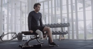 Young caucasian man taking a break before putting on prosthetic leg at the gym