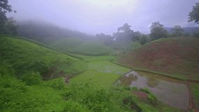 video motion of the atmosphere with rainy seasons mist surrounded by mountains in nature. There is a village for farming.
