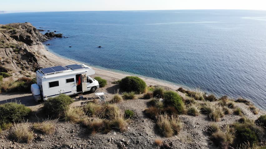 Aerial view. Camper car  with solar photovoltaic panels on roof camping on cliff sea shore. Mediterranean region of Villaricos, Almeria, eastern Andalusia, Spain. Royalty-Free Stock Footage #1109137519