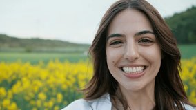 Video of beautiful young woman recording herself while enjoying spring in a field.