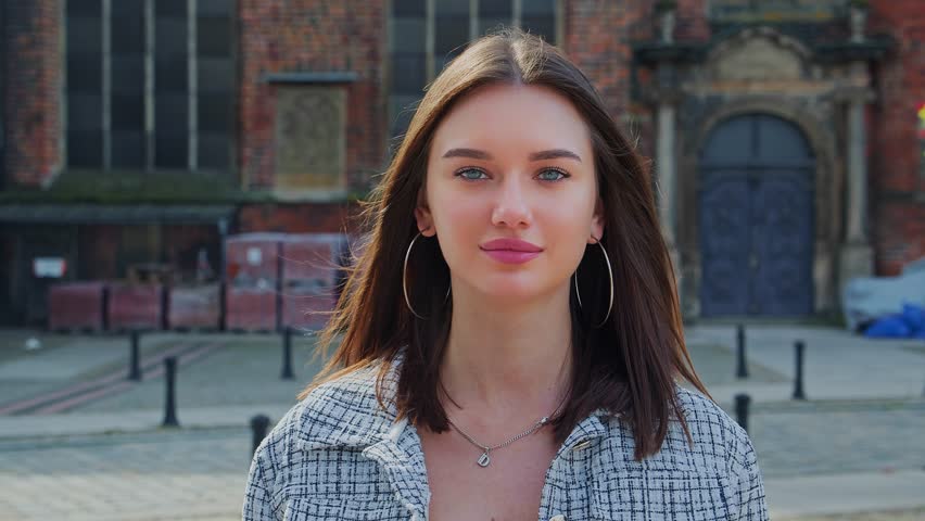 Beautiful smiling girl with long hair walks through the city. Portrait of modern woman | Shutterstock HD Video #1109140625