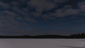 A time lapse of a snow covered frozen lake in the forests illuminated by moonlight on an extremely cold night in winter in Pirkanmaa, Finland - Powered by Shutterstock - Get 15% off with code: PIKWIZARD15