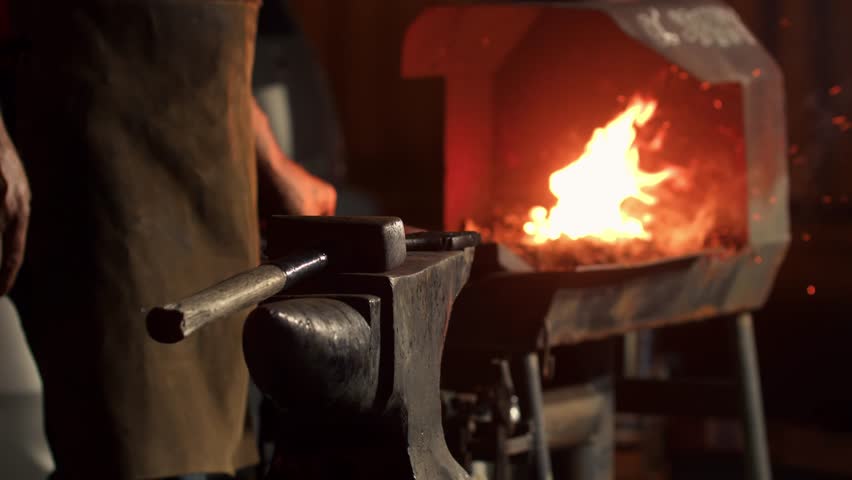 Blacksmith Heats Metal in a Furnace Close-up. Furnace in a Forge with a Fire, Man Heats the Metal Until it Melts so That he Can Hit it with a Hammer on the Anvil.