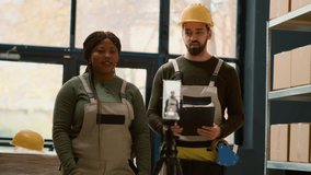 Warehouse employees using smartphone placed on tripod to make video for social media promoting the company. Coworkers filming themselves in storage room showcasing their daily tasks - Powered by Shutterstock - Get 15% off with code: PIKWIZARD15