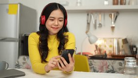 Cheerful Asian woman in headset laughing happily Listen to music, relax, use your laptop, stream video conference calls, teach online. hobby ideas work from home