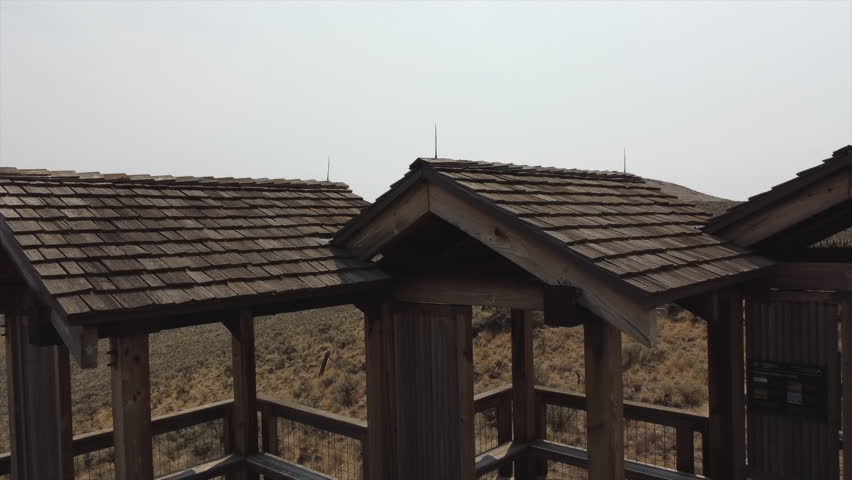Shirtless Man at Cliff Rest Stop on Oregon Trail midday in Summer 2021, Drone Pan Backwards