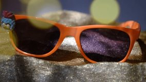 Close up trendy sunglasses on the golden sandy beach podium and sunlight flares. Honeymoon, travel, summer vacations concept