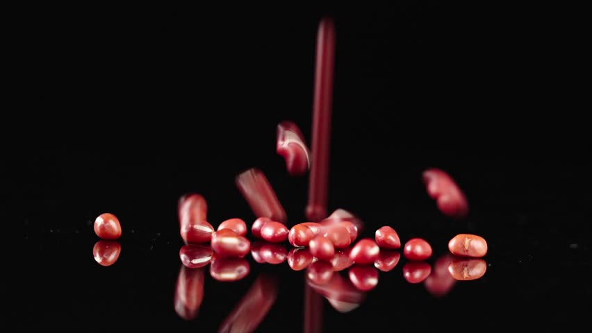 Falling of grain red  azuki beans
in slow motion,on a black background. 