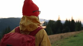 Woman hiker portrait, hiking backpacker traveler at sunset time. Beautiful mountain landscape view. Hiking, backpacking. 4K slow motion video