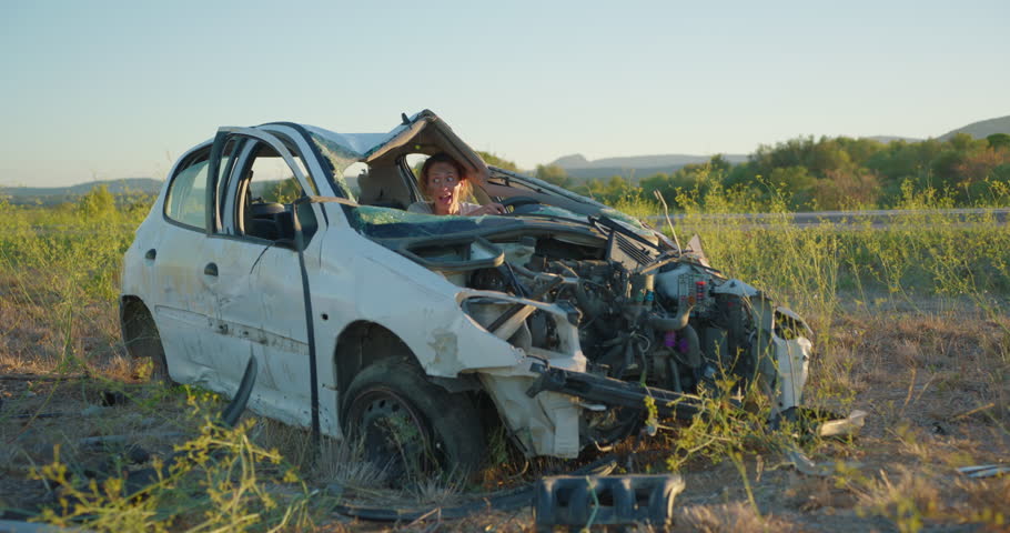 A woman sitting in a broken car after a car accident miraculously survived and cannot believe that she remained alive, looking around her in a state of shock Royalty-Free Stock Footage #1109163685