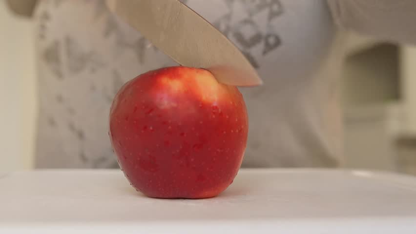 Woman uses sharp kitchen knife to cut ripe large red apples into slices. Preparing apples for drying. slow motion | Shutterstock HD Video #1109165755