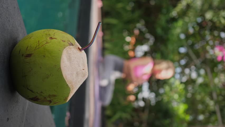 Mid adult woman sitting at namaste position, green fresh coconut is ready for drinking, outdoors exercises | Shutterstock HD Video #1109166901