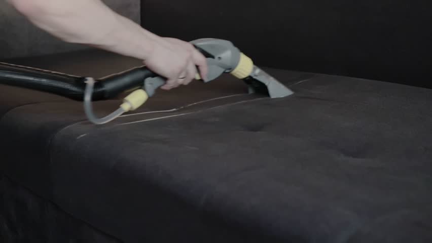 Dry cleaning of the black upholstery of the sofa with a special washing vacuum cleaner. Dry cleaning at home. Slow motion | Shutterstock HD Video #1109169125