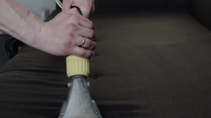 Dry cleaning of the black upholstery of the sofa with a special washing vacuum cleaner. Dry cleaning at home. Slow motion | Shutterstock HD Video #1109169127