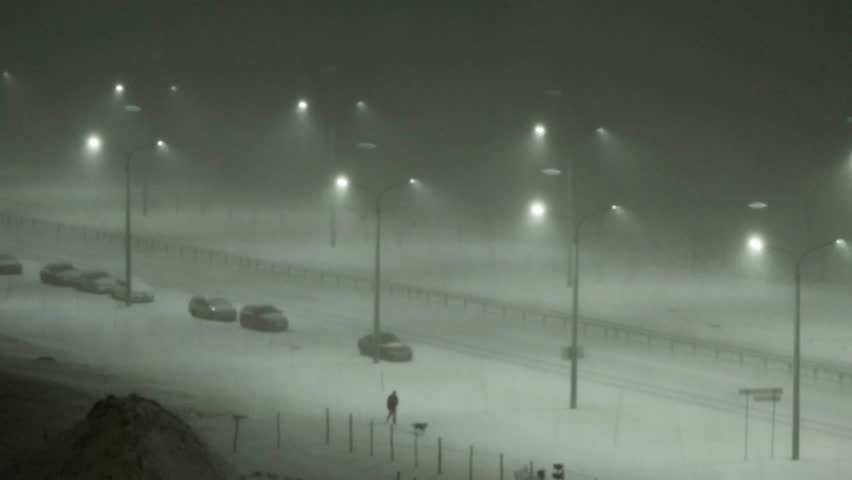 Snowstorm on the street outside the window at night. Wind with snow on the background of illumination of street lamps. Dangerous cyclone in winter. | Shutterstock HD Video #1109169157