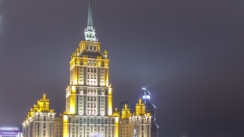 Iconic Hotel Ukraine, a Stalin-era skyscraper in Moscow, shines in the winter night. Timelapse captures its charm with Moscow River bridge and Moscow-City in the backdrop. Russia