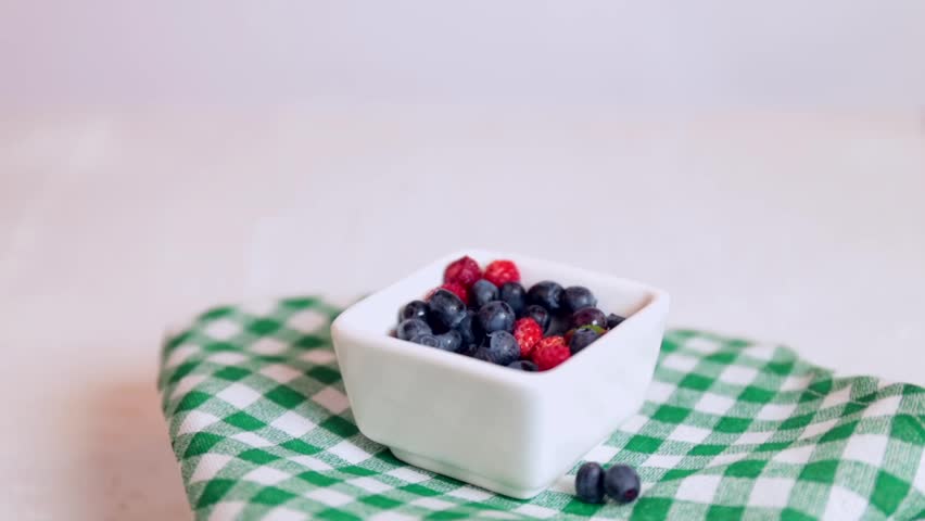 Fresh wild berries in a white bucket on a light background, rotating. seasonal berries (strawberries, blueberries), rotation in circle. pour the berries | Shutterstock HD Video #1109170555