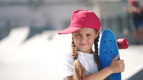 Portrait child girl skateboarder on the playground. Girl skateboarder on the background of the urban landscape area lifestyle. happy family child dream concept. Skateboarder girl child outdoor