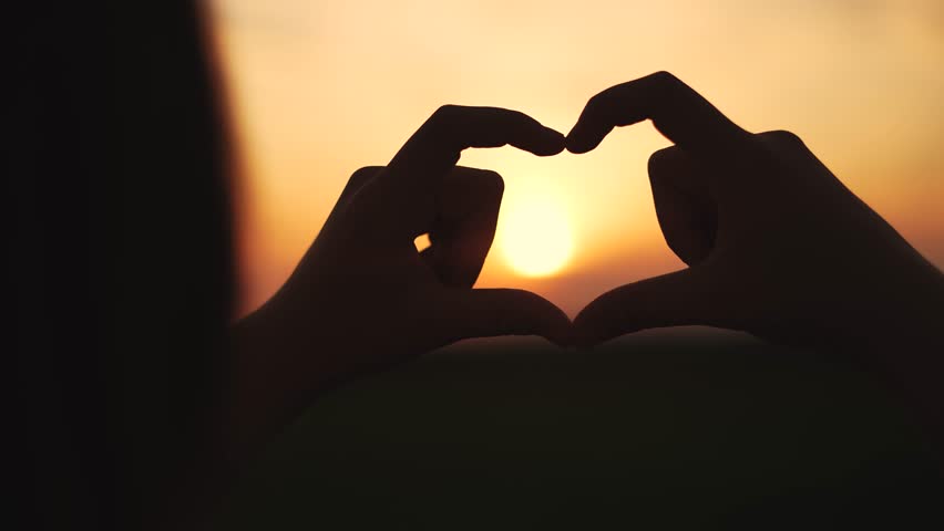 hands make a heart at sunset.happy family kid dream concept. hands in the foreground fold the figure from the fingers. a heart of fingers folded in lifestyle a field at sunset Royalty-Free Stock Footage #1109170877