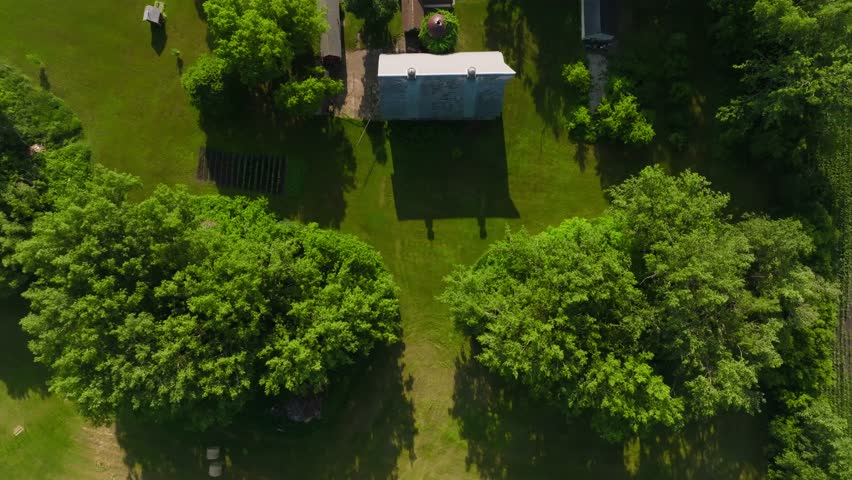 top down drone shot of a large farm with multiple barn structures and out buildings on a sunny day