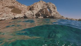 View from water level - Seascape, view of coastal cliff on blue sky background, Camera moving forwards, Rhodes island, Mediterranean sea, Greece