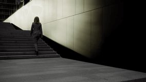 Back view of charming caucasian lady in stylish business wear and high heels walking on staircase outside modern office building. Shadow of female silhouette leaving on grey wall. - Powered by Shutterstock - Get 15% off with code: PIKWIZARD15