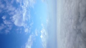 Vertical video. Cloudy blue sky background. Aerial view.