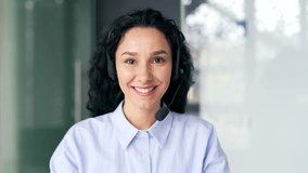 Close up. Webcam view. Woman in wireless headset customer service operator talking on video call sitting in office. Agent of the call center advises the client, answering questions looking in camera - Powered by Shutterstock - Get 15% off with code: PIKWIZARD15