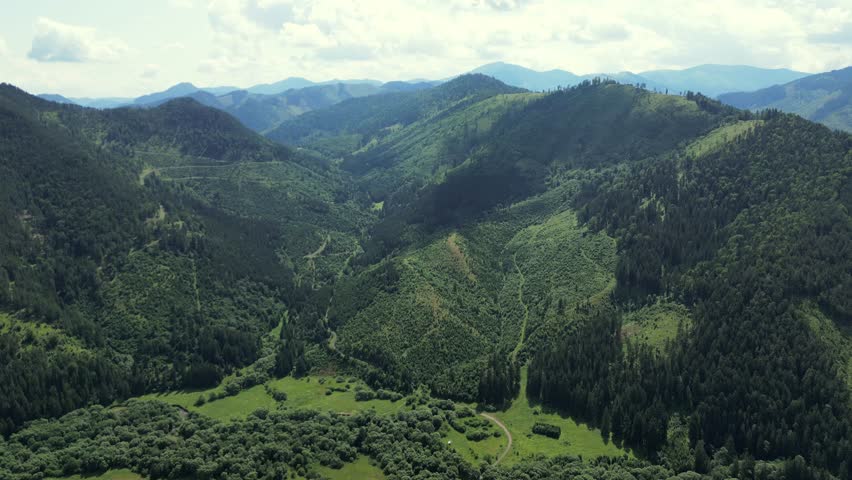 Mountains in Slovakia, peaks, cliffs, rocks, ridges, landscape, green grass, sky. Mountain summer landscape, aerial view. Green mountain valley. National Park High Tatra, Slovakia, Europe.