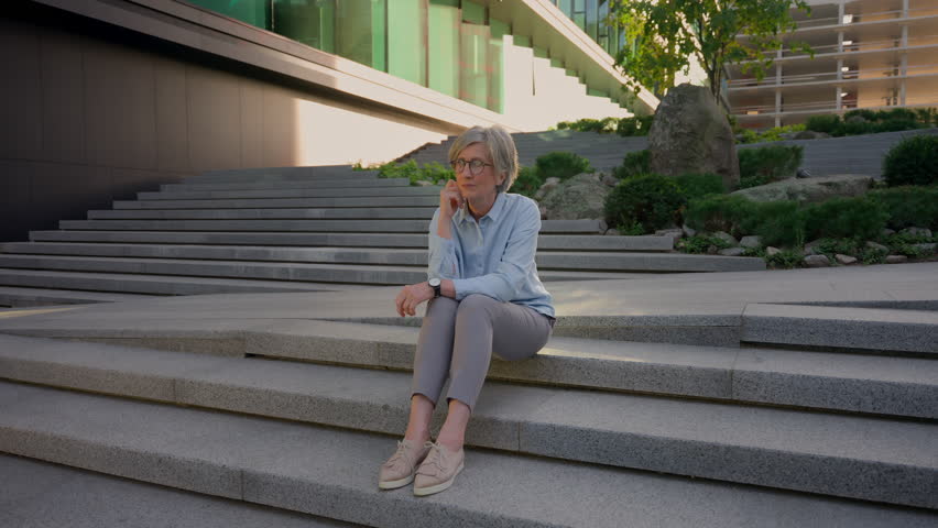 Caucasian tired business woman mature old senior sick unwell businesswoman on city stairs rest overwork hard day exhausted female in city feel eyes pain headache eyestrain take off glasses bad vision | Shutterstock HD Video #1109197783